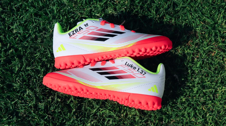 Personalised adidas boots on grass with player name and Bible verse