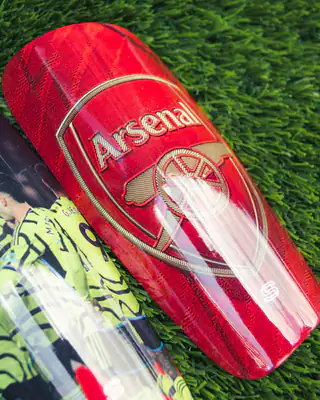 Arsenal gold crest shin pad on red